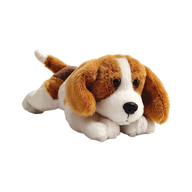Beagle che giaceva un giocattolo da cucciolo di peluche di peluche di peluche.